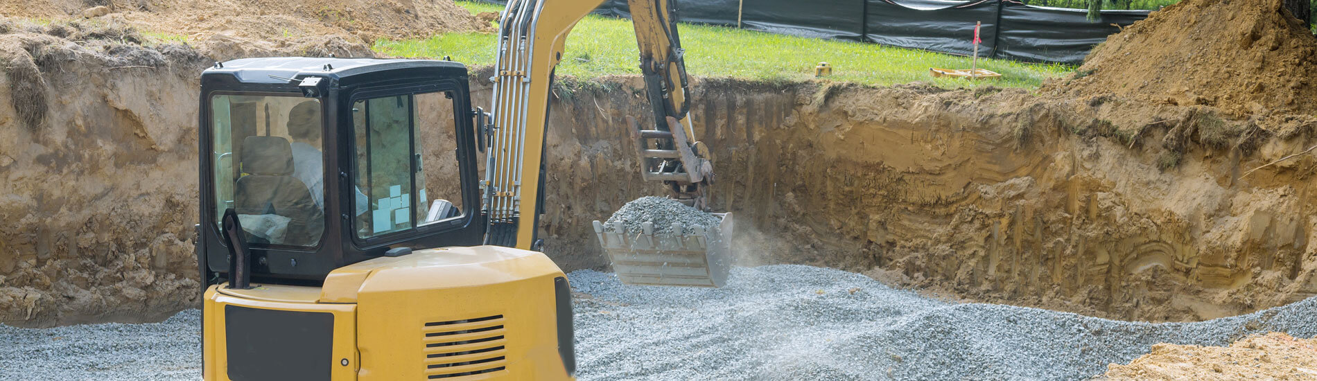 Excavator Digging Bucket Scooping Gravel From A Building Foundation